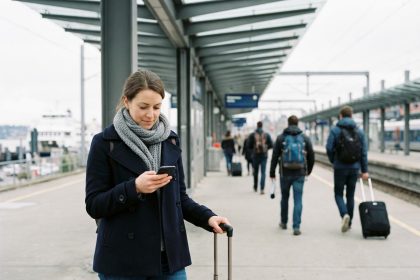 Jeune femme en manteau sur une plateforme de gare portuaire