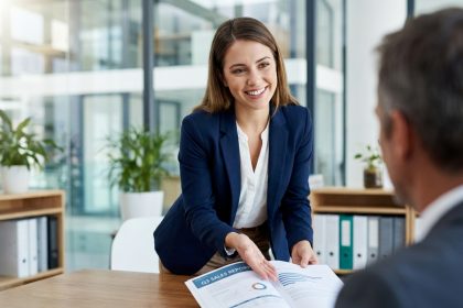 Femme d'affaires souriante présente un rapport de vente en réunion